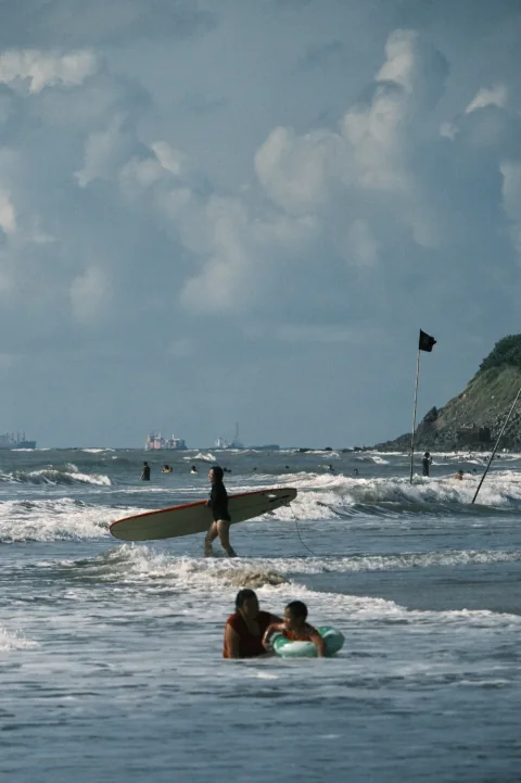 People practising with surfboards in shallow water.
